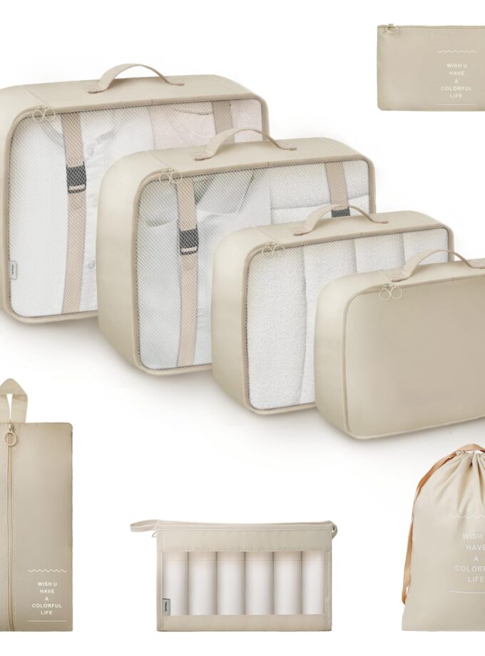 Beige 8-piece packing cube set from GRANNY SAYS, including various bags for organizing travel essentials, shown with travel gear